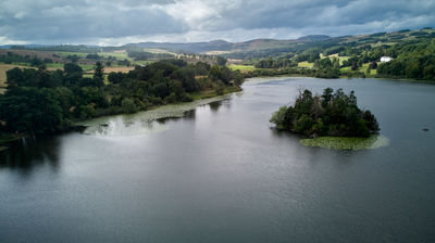 An aerial view of a Scottish loch with a small green island