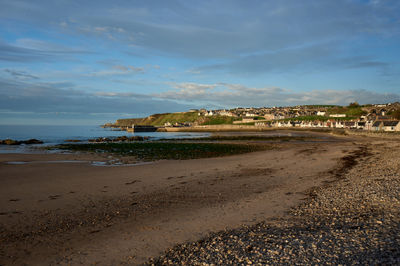 The Beauty of Nature on Display: Evening sky over the beach and a coastal town at distance.