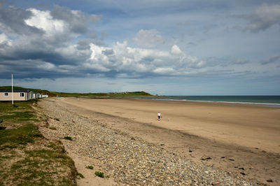 An empty beach and a sea at a distance under a picturesque sky