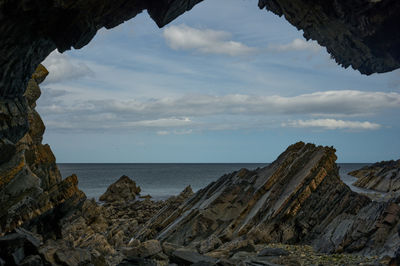 A sea view through the big hole in a strangely shaped rock