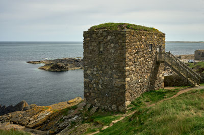 A strange old small cubic building on a seaside