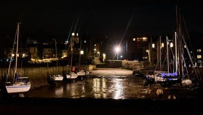 Queensferry harbour with boats at low tide at night