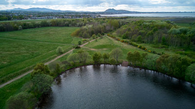 Musselburgh Lagoons. A green field and a small lake