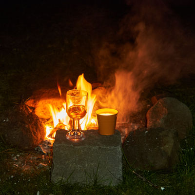 A glass of wine at the campfire at night