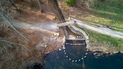 Aerial view - a lake, footpath and a bridge in a forest near Zurich