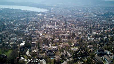 Aerial view of houses in Zurich suburb. Lake Zurich at distance