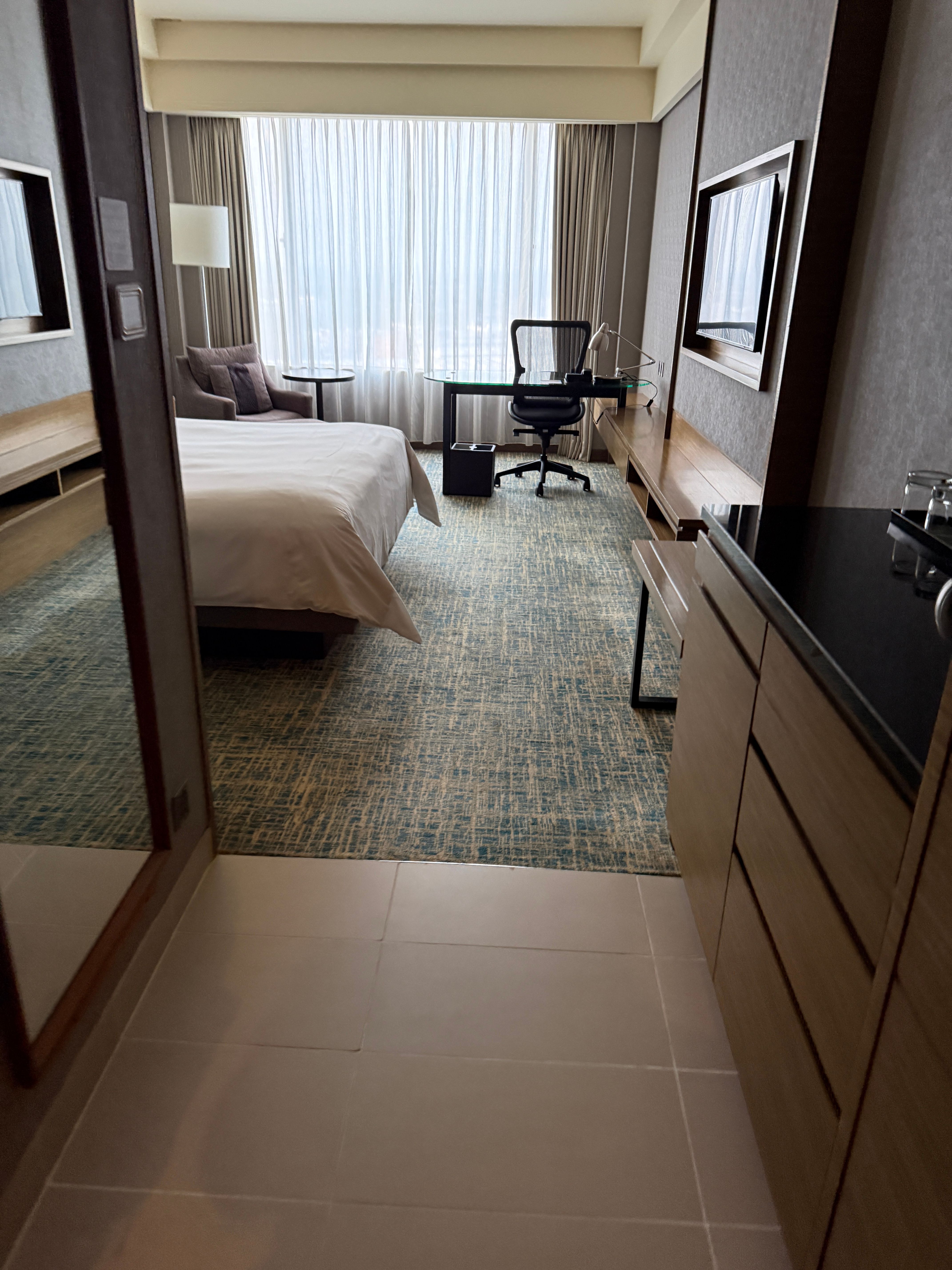 Renaissance Hotel JB guest room from the tiled entry looking toward bed desk and window