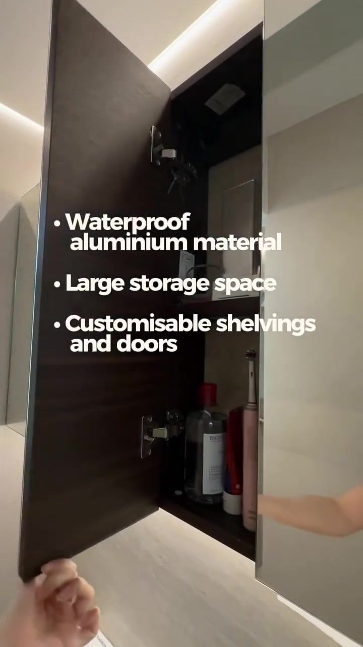 Mirrored bathroom cabinet door held open showing dark interior shelves with toiletries, overlay waterproof aluminium large storage customisable shelvings and doors