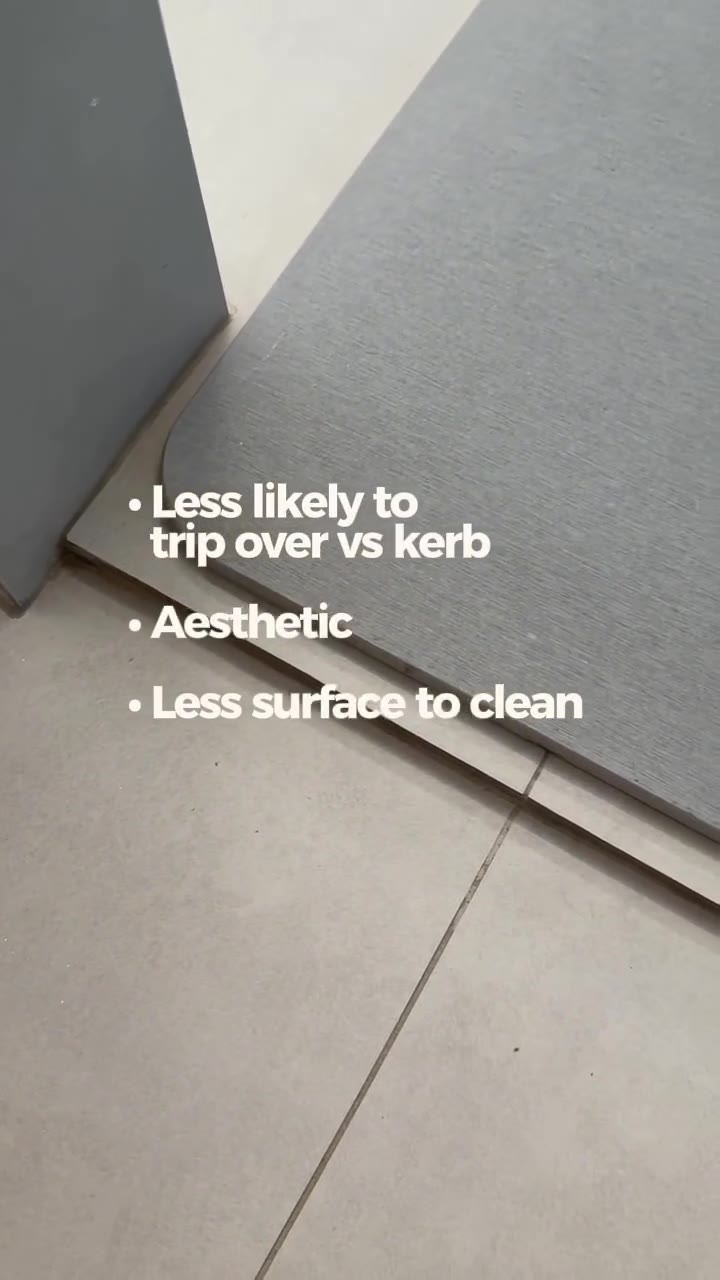 Drop-down shower floor edge with grey bath mat on the dry side, overlay less likely to trip over vs kerb, aesthetic, less surface to clean