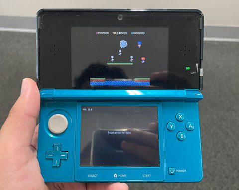 a photo of a 3DS running the NES game balloon fight