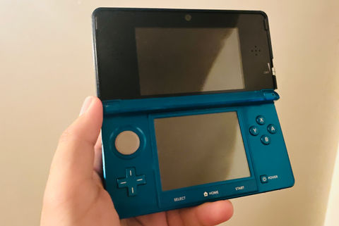 an aqua-blue 3DS being held