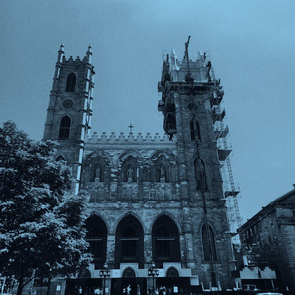 A stone basilica with scaffolding around one tower.