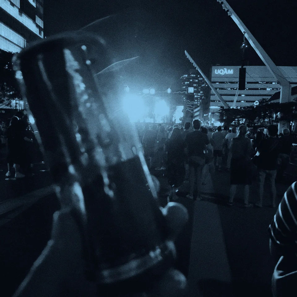 A crowd gathered beneath bright lights at an outdoor concert.