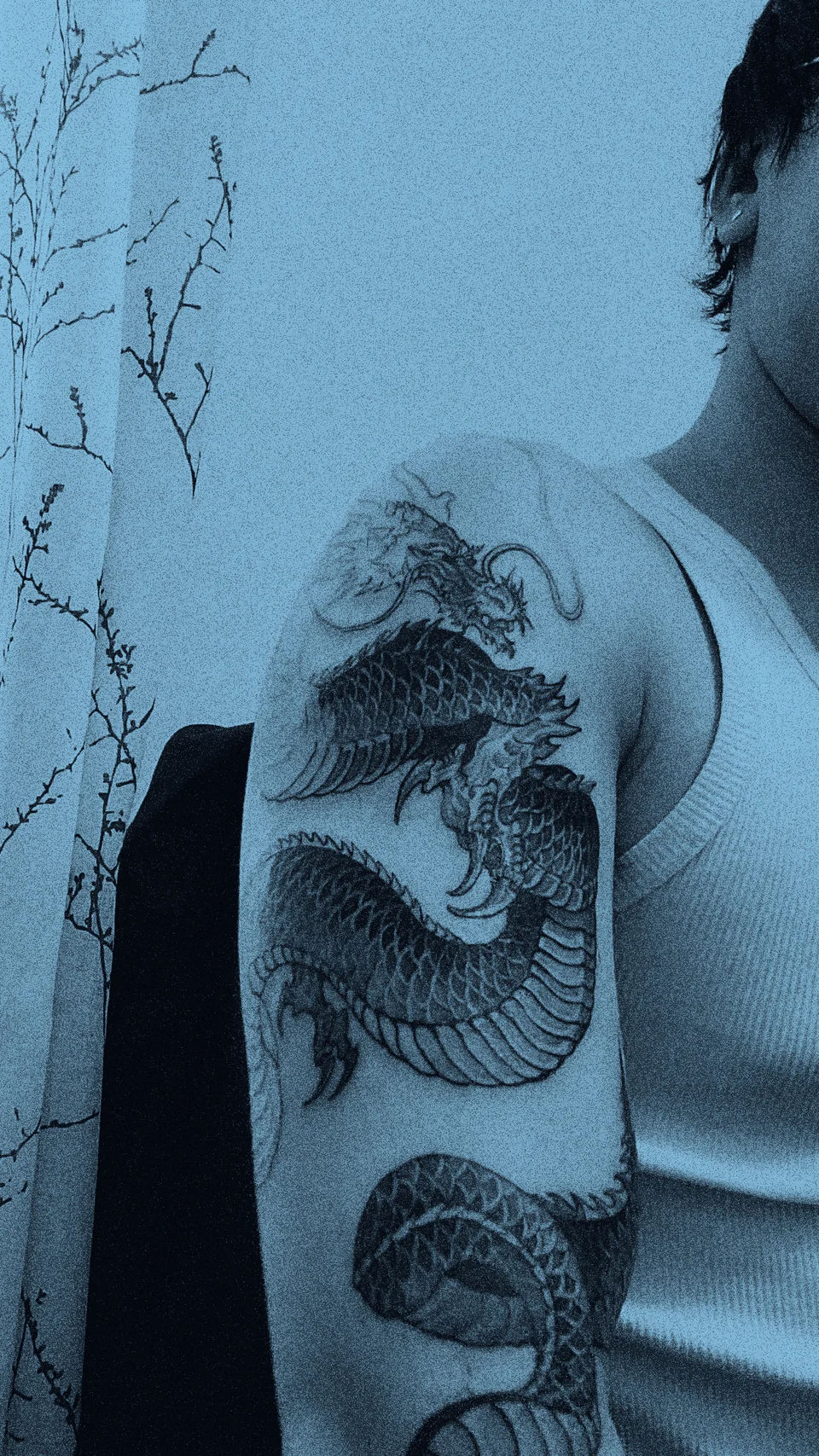 A dragon tattoo winding around an upper arm.