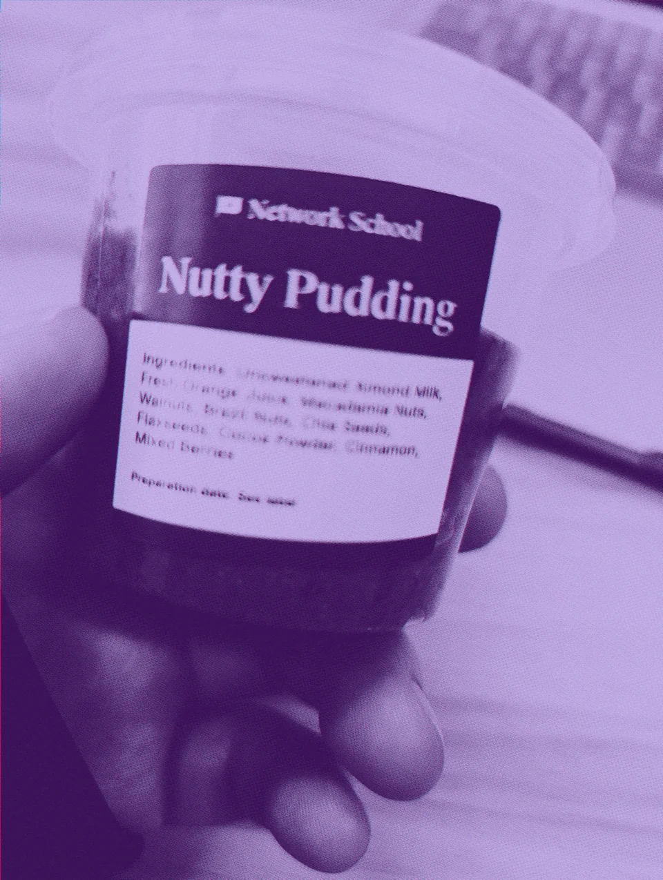 A cup of nutty pudding held above a desk.