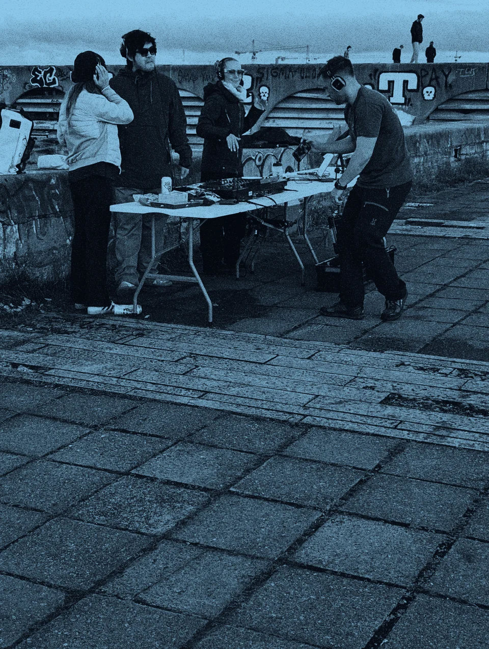People gathered around an outdoor DJ setup.