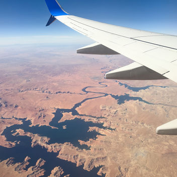 A cropped shot of an aeroplane wing mid-flight.
