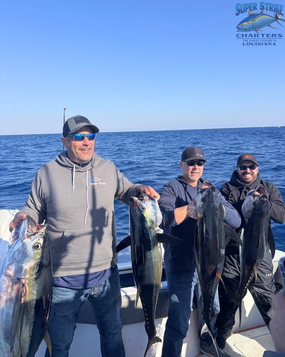 3 anglers holding up their yellowfin tuna during April fishing