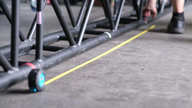 Ein Crew-Mitglied arbeitet mit dem Maßband für präzise Aufbaumaße