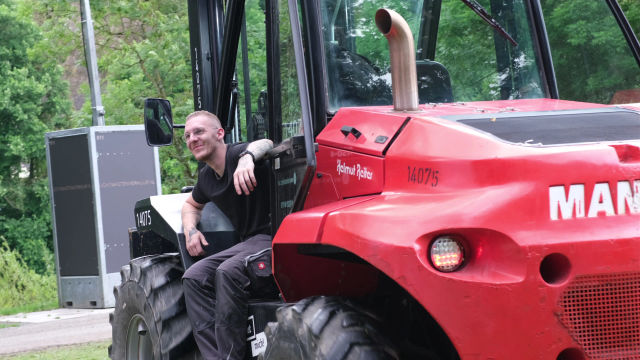 Ein Crewmitglied lächelt auf dem Stabler bei der Arbeit