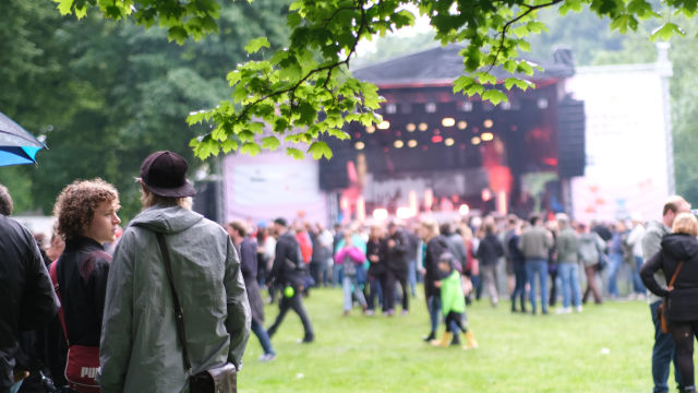 Fernaufnahme mit fokussierten Menschen unter dem Baum beim 40. Jubiläum des Pfingst Open Air