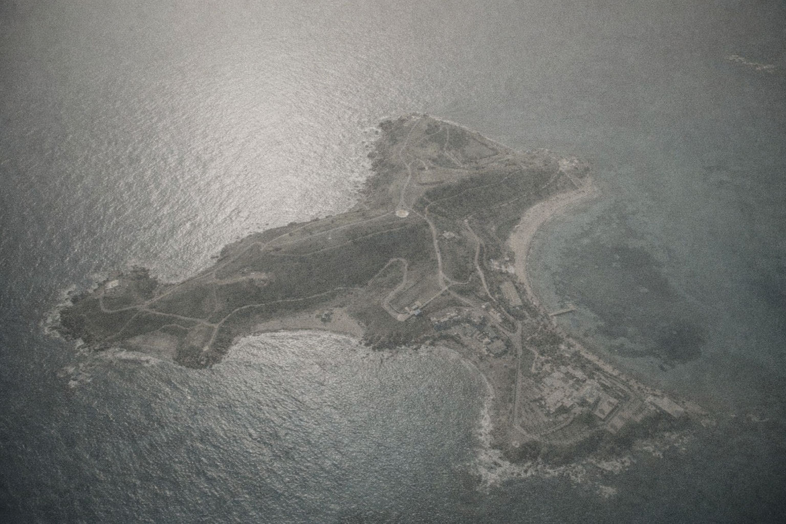 Aerial view of a remote island surrounded by ocean, used as a symbolic representation of isolation.