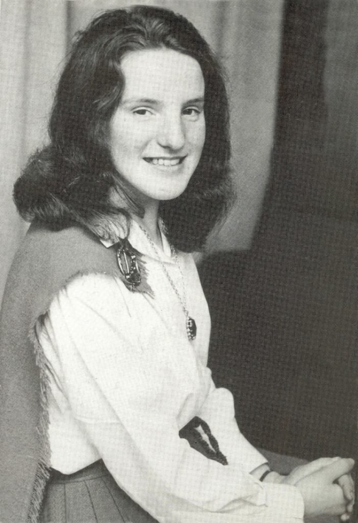 Old black and white photo of a smiling woman with long dark hair