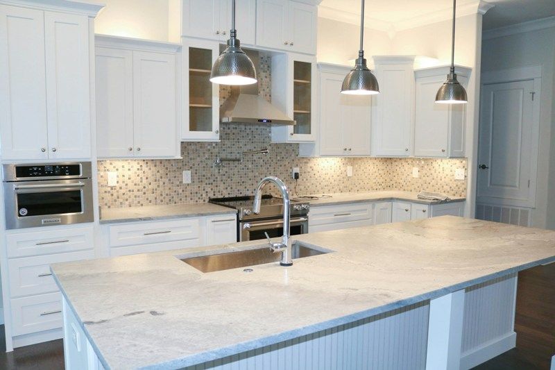 White marble kitchen island with brass fixtures