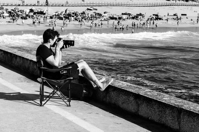 Use this high-quality image of black and white image of a photographer at a beach in aveiro in blogs, ads, or creative design projects.