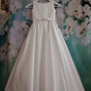 Classic Duchesse satin communion dress with pearl bow detailing and box pleat skirt. Made in Glasgow
