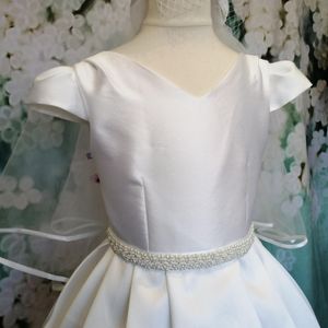 Mikado communion gown with pleated sleeves and skirt. Stunning pearl belt on waist. Made to measure in Glasgow