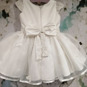 Ivory satin flower girl dress with lace cap sleeve, belt and bow. Made to order in Glasgow