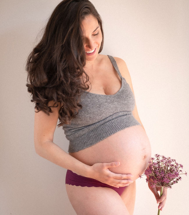 Eine schwangere Frau in der 38. SSW mit Blumen