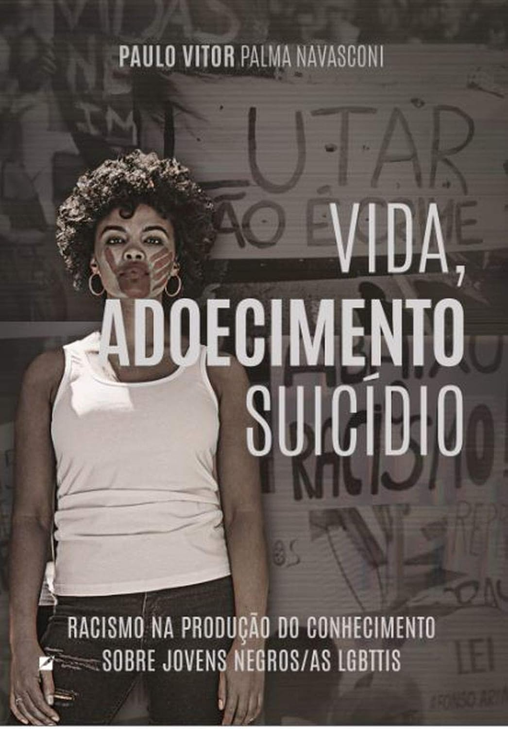 Capa do livro Lutar pela vida, adoecimento e suicídio: racismo na produção do conhecimento sobre jovens negros/as LGBTIs, de Paulo Vitor Palma Navasconi. À esquerda, uma pessoa negra de cabelos crespos, usando regata branca, brincos de argola e pinturas claras no rosto, posa diante de um muro com inscrições e grafites. O título aparece em letras brancas grandes sobre a imagem, em tons escuros e acinzentados.