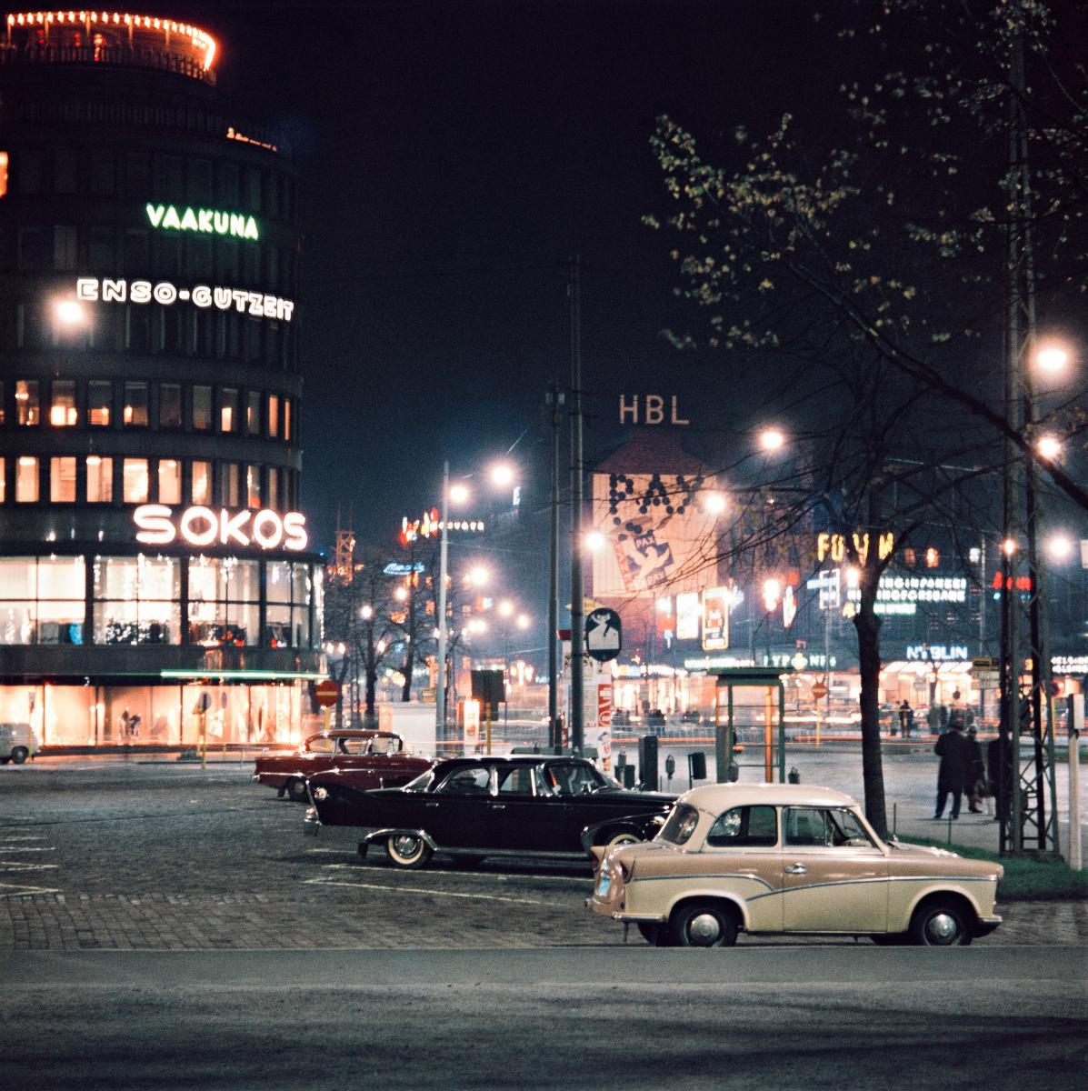 Autoja parkissa Mannerheiminaukiolla Sokos -tavaratalon vieressä. Kuva: Helsingin kaupunginmuseo.