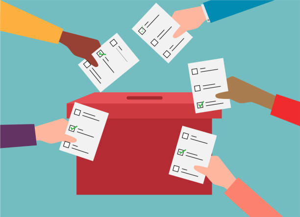 Cartoon image of many people voting represented by several hands holding voting cards in front of a ballot box