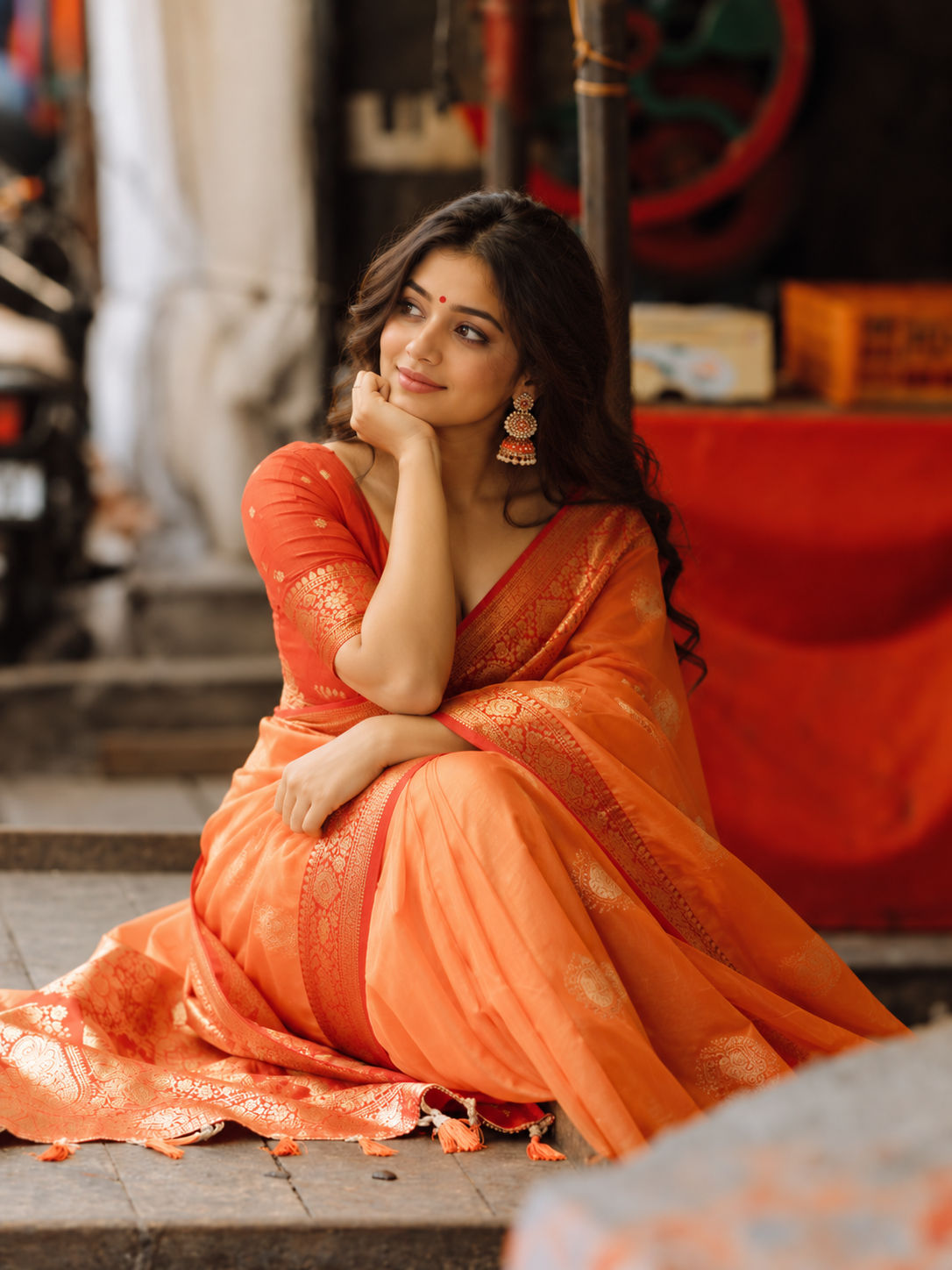 Woman wearing red saree on a balcony