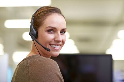 Rheem Customer Service Rep Sitting at Her Desk and Smiling Over Her Shoulder