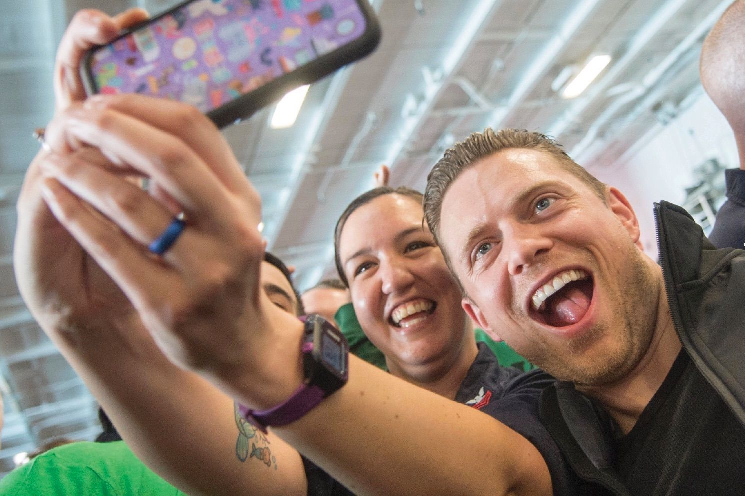 People clearly enjoying the moment of taking a group selfie.