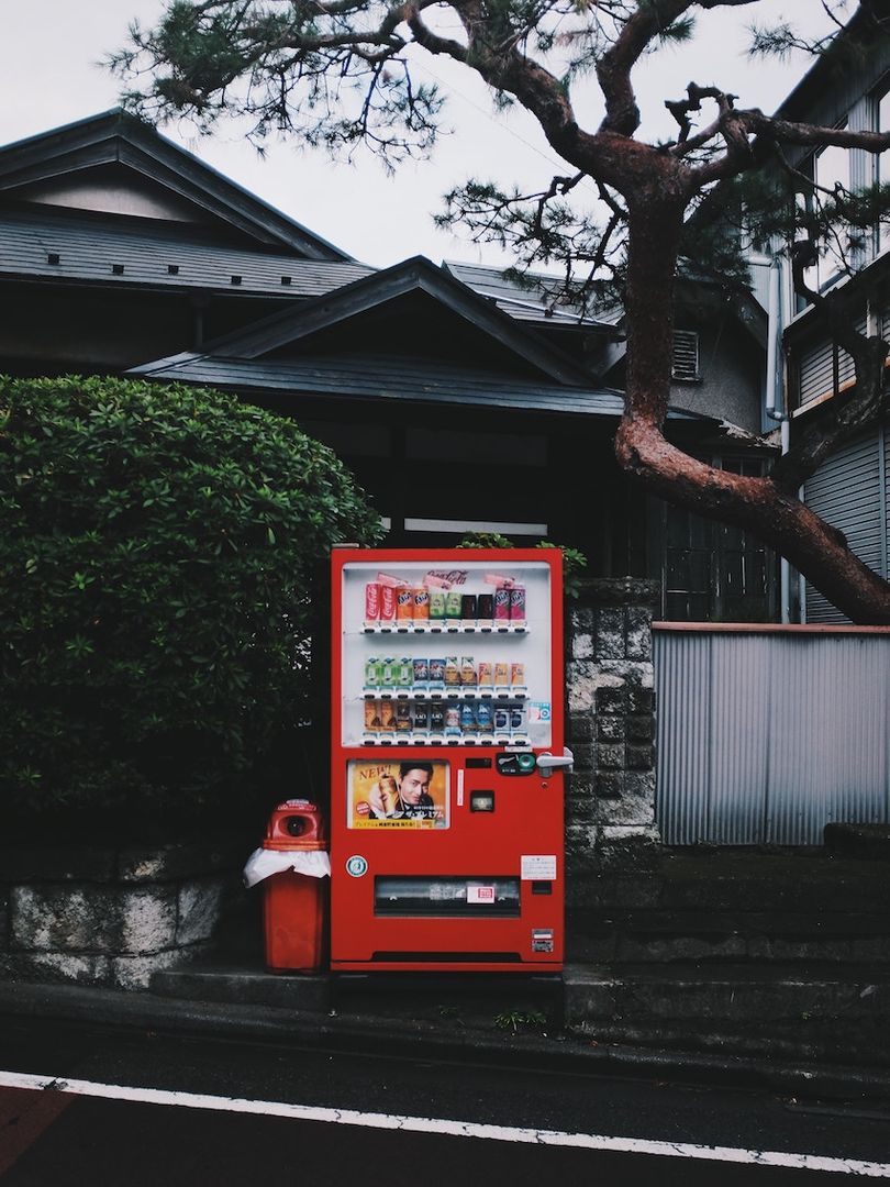 A bright red vending machine on a street