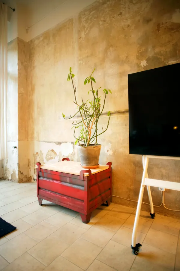 Presentation area with TV screen and historic wall at KOTEKA seminar space Leipzig