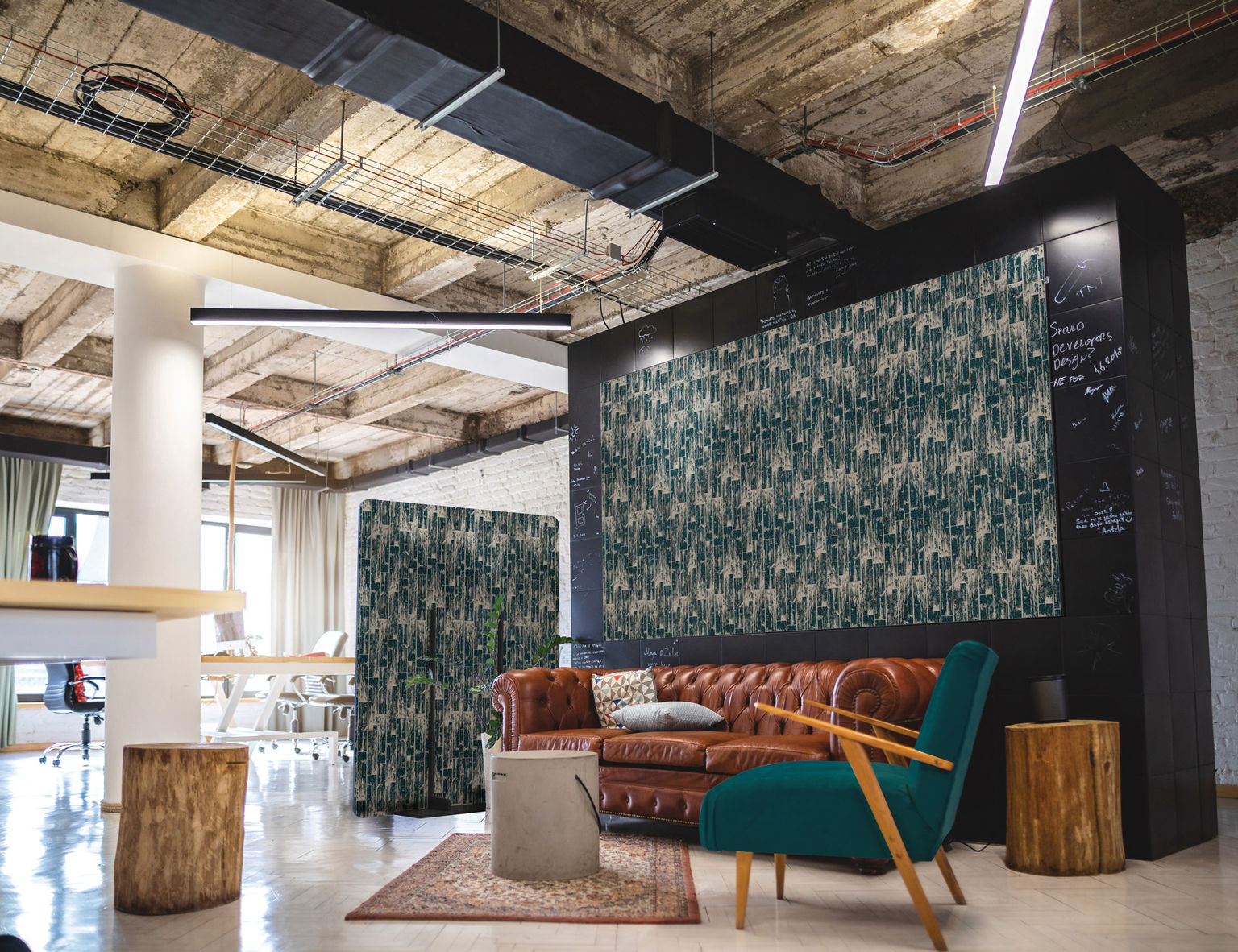 An eclectic office space featuring custom-printed acoustic wall panels and freestanding partitions in a lounge seating area.