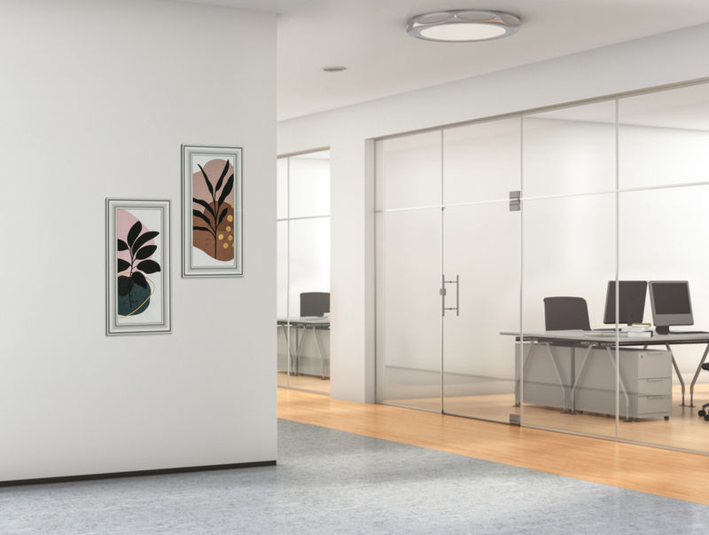 A corporate office hallway with two vertical magnetic frames with custom printed artwork inserts.