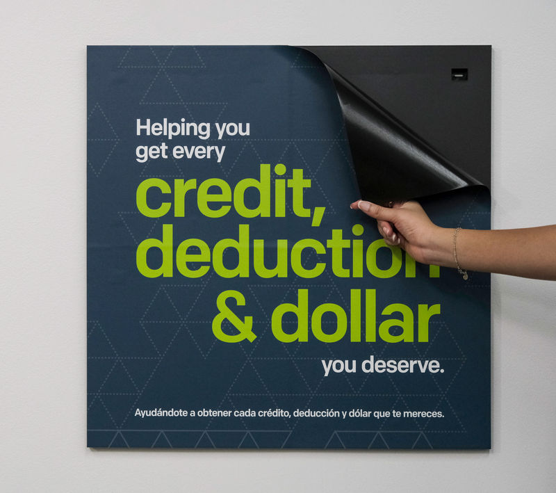 A woman replacing a magnetic graphic promoting a credit union