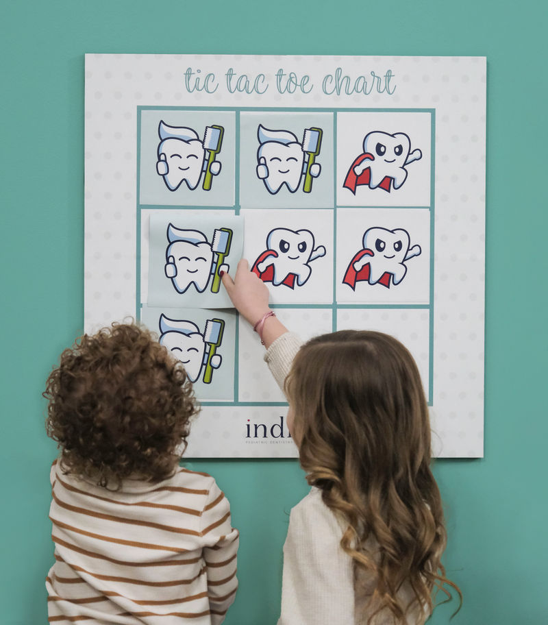 Children interacting with magnetic tic-tac-toe game in a dentist office