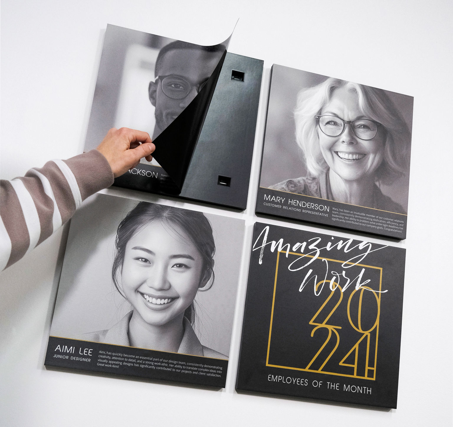 A hand changing one of four magnetic wall graphics for an employee recognition display