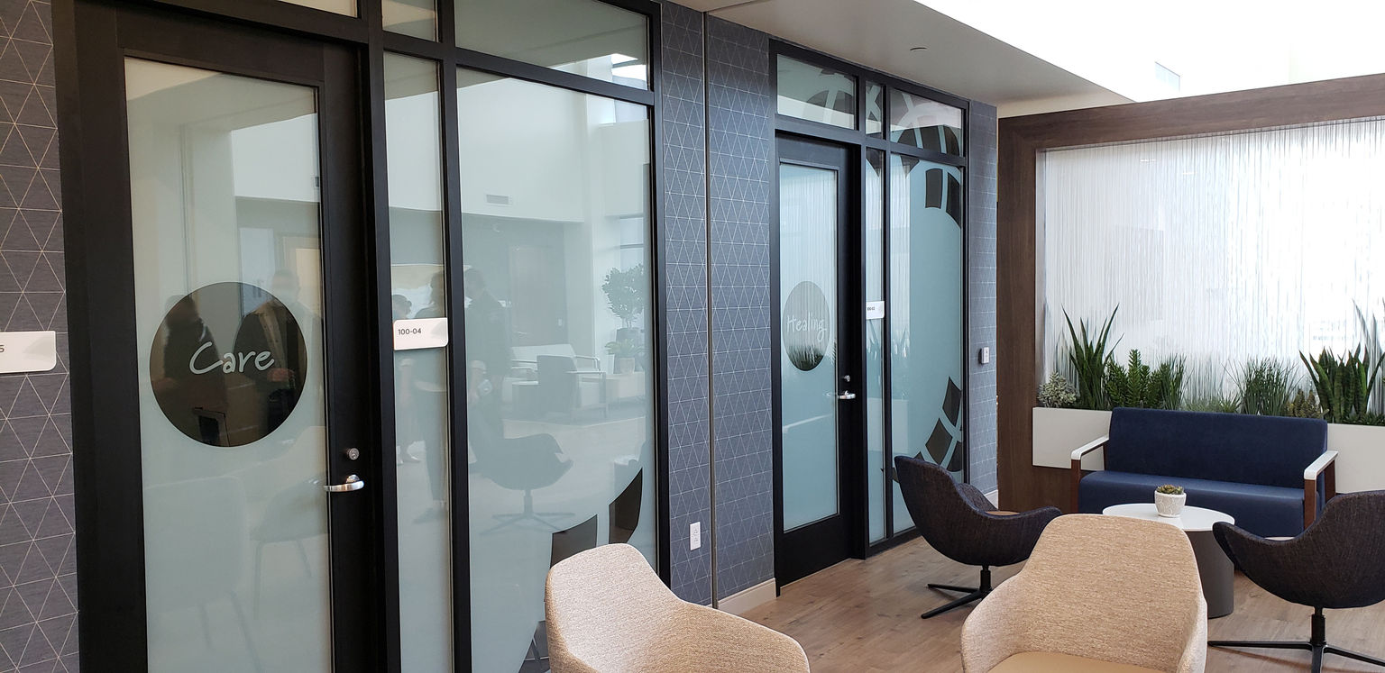 Behavioral health counseling offices with branded privacy window film and high-acuity room identification signage.