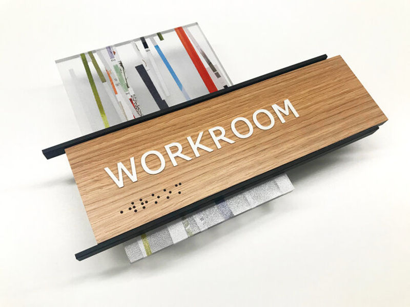 A workroom sign designed for Georgia Pacific featuring Wilsonart 7996-38 Natural Recon, 3form Papercut with sandstone finish, and black accent bars.