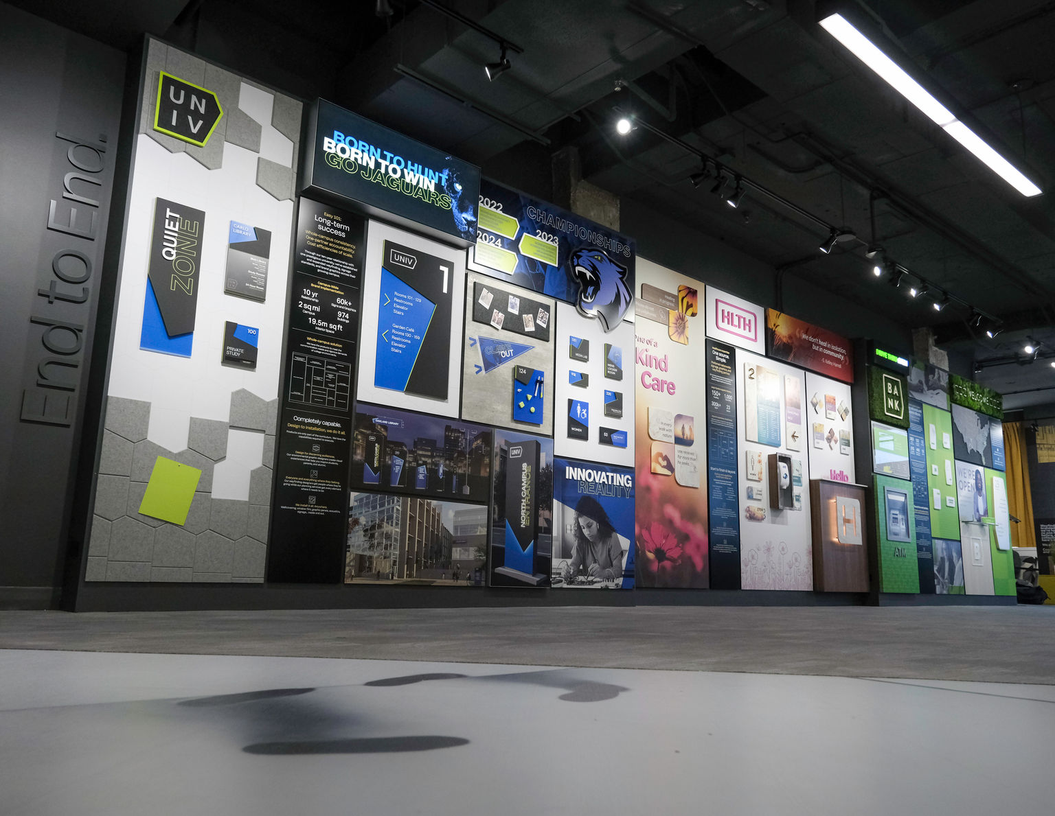 Showroom project wall featuring signage and experiential graphics for higher education, healthcare, and corporate environments.
