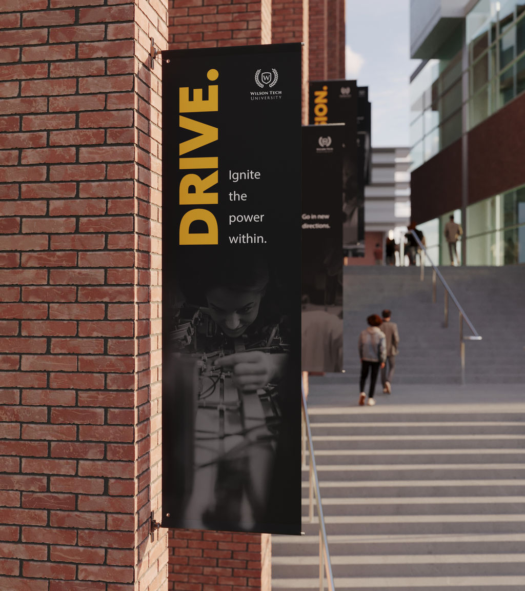 Multiple pole banners fixed to an exterior building of a busy college campus